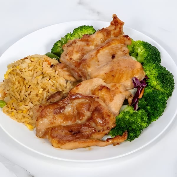 Hibachi chicken with fried rice and broccoli on a white plate.