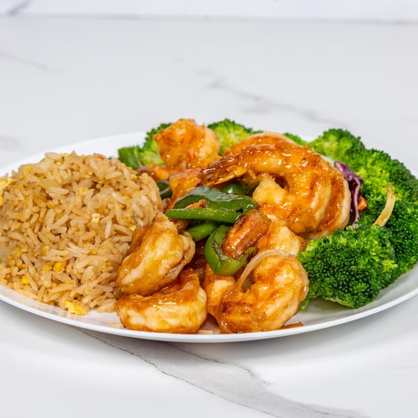 Hibachi shrimp with green peppers, onions, and broccoli, served with a side of fried rice.